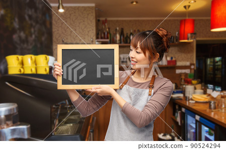 happy female barista with chalkboard at restaurant 90524294