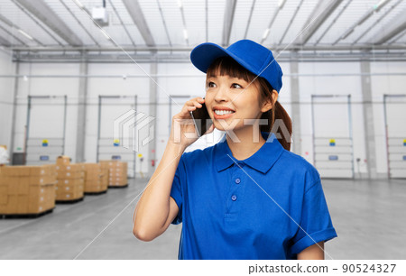 happy delivery woman calling on phone at warehouse happy delivery woman calling on phone at warehouse 90524327