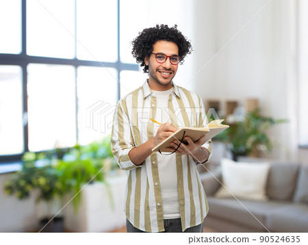 happy smiling man with diary and pencil at home 90524635