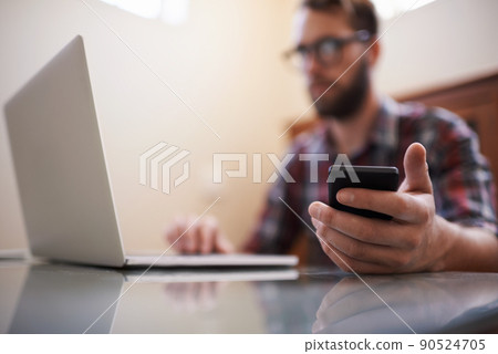 Using all the latest tech. Shot of a handsome young hipster working on a laptop. Using all the latest tech. Shot of a handsome young hipster working on a laptop. 90524705