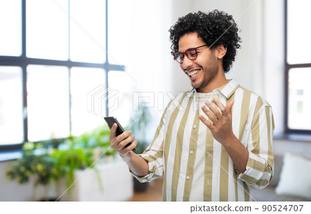 happy smiling young man with smartphone at home happy smiling young man with smartphone at home 90524707