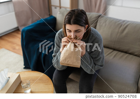 woman having panic attack breathing to bag at home woman having panic attack breathing to bag at home 90524708