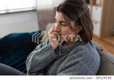 stressed woman sitting on sofa at home stressed woman sitting on sofa at home 90524749