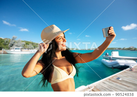 smiling woman in bikini taking selfie on pier smiling woman in bikini taking selfie on pier 90524838