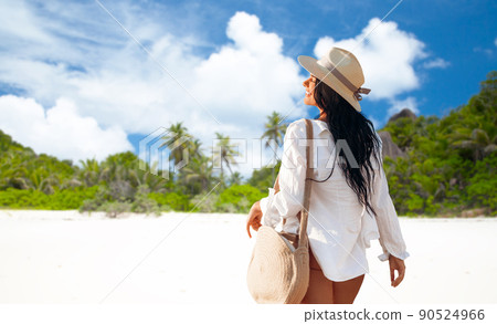 happy woman with bag walking along summer beach 90524966
