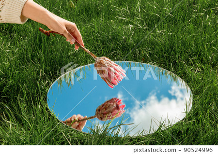 hand with flower and sky reflection in mirror hand with flower and sky reflection in mirror 90524996