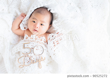 50-day-old healthy baby lace key knitting looking at the camera with letters 90525272