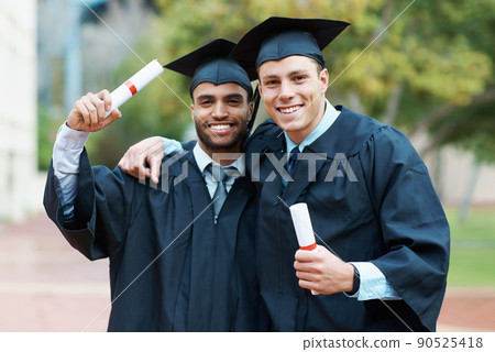 Were on our way to success. Two young college graduates holding their diplomas while wearing cap and gown. Were on our way to success. Two young college graduates holding their diplomas while wearing cap and gown. 90525418