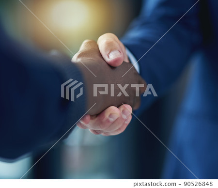 The deal is struck. Cropped shot of two businesspeople shaking hands in the boardroom. 90526848
