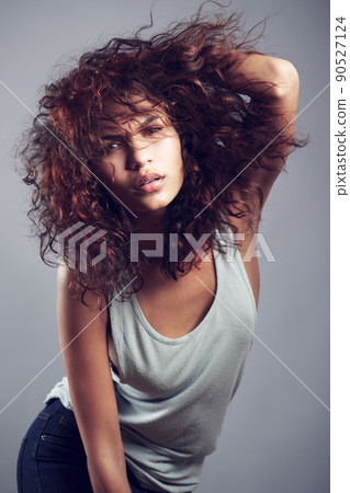 Shes got it. Studio shot of a gorgeous young woman posing against a gray background. Shes got it. Studio shot of a gorgeous young woman posing against a gray background. 90527124