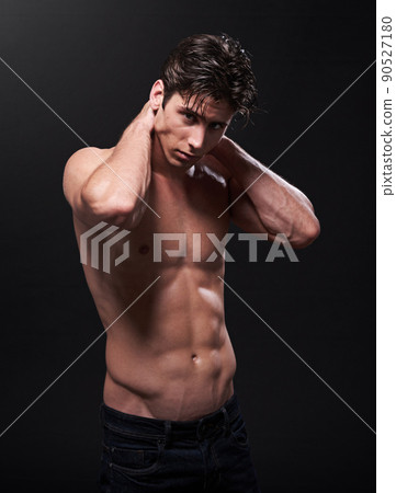 This is what dedication looks like. Studio shot of a handsome bare-chested young athlete standing against a black background. This is what dedication looks like. Studio shot of a handsome bare-chested young athlete standing against a black background. 90527180