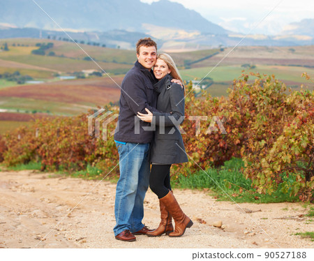 They are in their element. Portrait of a young couple standing together in the vineyards. They are in their element. Portrait of a young couple standing together in the vineyards. 90527188