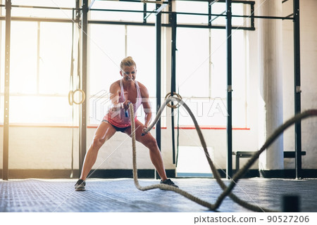 Youre only getting stronger. Shot of a sporty young woman working out with heavy ropes at the gym. Youre only getting stronger. Shot of a sporty young woman working out with heavy ropes at the gym. 90527206