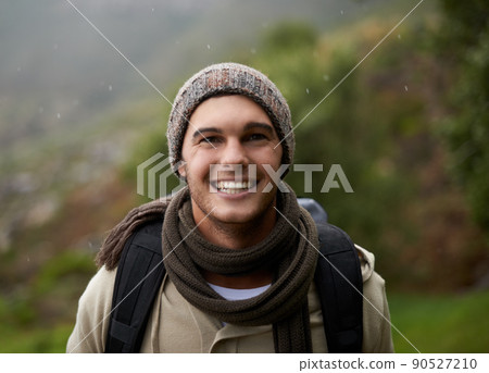 He has a great love for the outdoors. Portrait of a handsome young man standing in the mountains. He has a great love for the outdoors. Portrait of a handsome young man standing in the mountains. 90527210