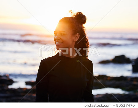 Change your thoughts and you change your life. Shot of an attractive young woman standing alone after doing yoga on the beach at sunset. 90527470
