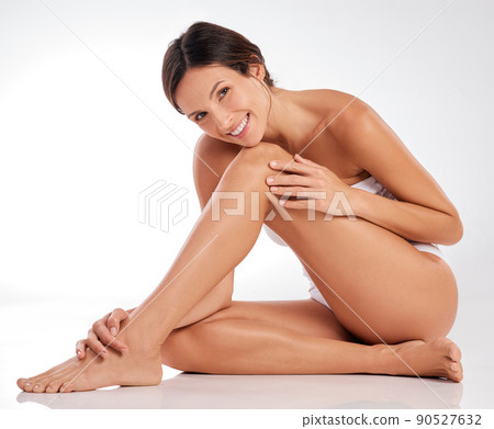 Covered in self-love from head to toe. Full length shot of an attractive young woman sitting alone in the studio and posing. Covered in self-love from head to toe. Full length shot of an attractive young woman sitting alone in the studio and posing. 90527632
