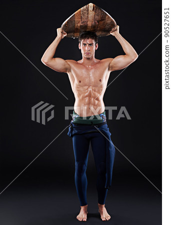 Ready to rock the beach. Full length studio shot of a young surfer with a vintage board. Ready to rock the beach. Full length studio shot of a young surfer with a vintage board. 90527651
