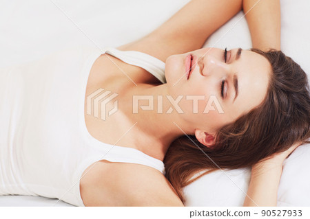 Catching some shut-eye. Shot of a young woman sleeping on her bed. Catching some shut-eye. Shot of a young woman sleeping on her bed. 90527933