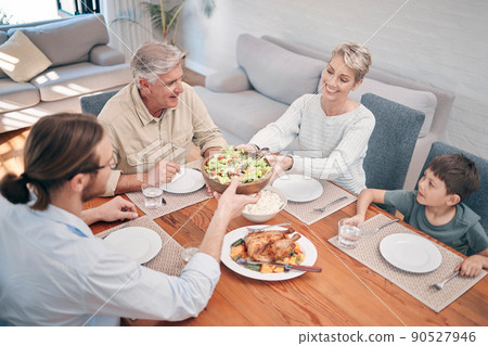 When we share our food, we share our hearts. Shot of a family enjoying a meal together at home. When we share our food, we share our hearts. Shot of a family enjoying a meal together at home. 90527946