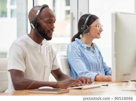 Taking this day one call at a time. Shot of two call center workers together. Taking this day one call at a time. Shot of two call center workers together. 90528098