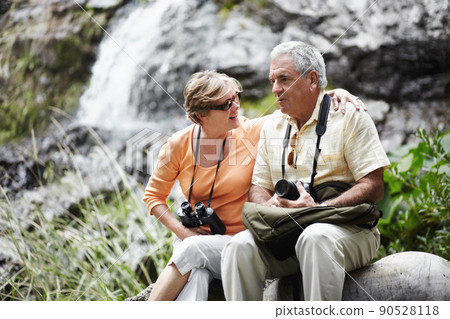Taking a breather.... A senior couple taking a break while out walking in the forest together. Taking a breather.... A senior couple taking a break while out walking in the forest together. 90528118