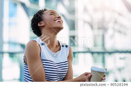 She starts her morning with the right attitude. Cropped shot of an attractive young businesswoman laughing while sitting in a modern workplace. She starts her morning with the right attitude. Cropped shot of an attractive young businesswoman laughing while sitting in a modern workplace. 90528194