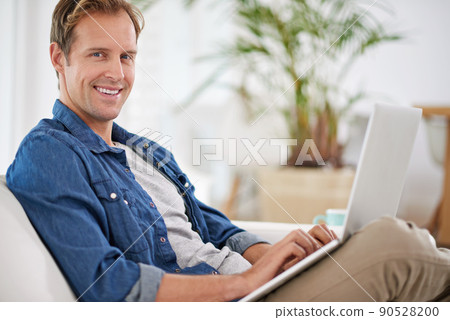Lazy day with my laptop. Portrait of a handsome man using his laptop at home. Lazy day with my laptop. Portrait of a handsome man using his laptop at home. 90528200