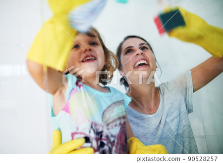 Making chores fun. Shot of a mother and daughter doing chores together at home. Making chores fun. Shot of a mother and daughter doing chores together at home. 90528257