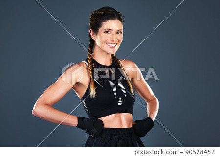 Getting fit for the betterment of my health. Studio shot of a fit young woman posing against a grey background. 90528452