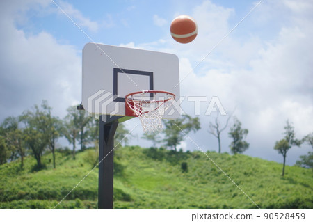 Basketball thrown towards the basketball goal Basketball thrown towards the basketball goal 90528459