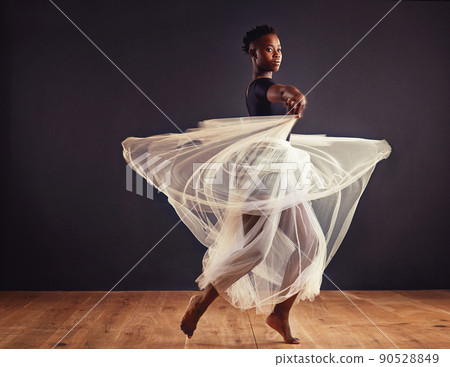Poetry in motion. Young female contemporary dancer using a soft white white skirt for dramatic effect. Poetry in motion. Young female contemporary dancer using a soft white white skirt for dramatic effect. 90528849