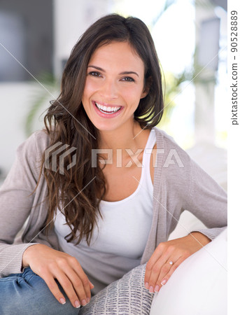 Waiting to surprise him with a smile. Cropped shot of a gorgeous young woman on a couch. 90528889