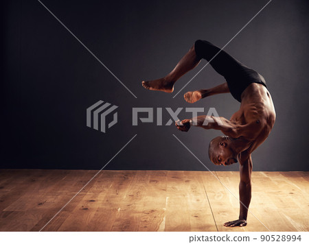 Dedication, passion, commitment. Male dancer performing an acrobat move. Dedication, passion, commitment. Male dancer performing an acrobat move. 90528994
