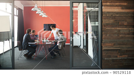 Lets get strategizing. Shot of a group of colleagues having a meeting in a boardroom. 90529118