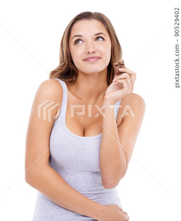 Small indulgences. An attractive young woman enjoying a slab of chocolate. 90529402