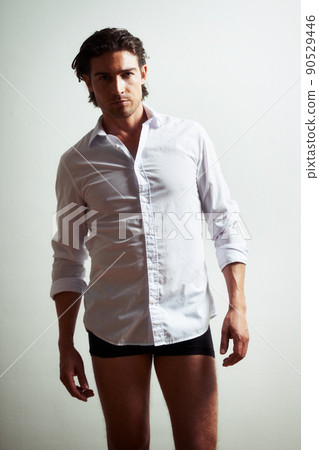 The seductive stare. Portrait of a sexy young man in a shirt and underwear. The seductive stare. Portrait of a sexy young man in a shirt and underwear. 90529446