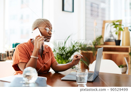 If you plant hard work now, you will harvest success later. Shot of a young businesswoman talking on a cellphone while working on a laptop in an office. 90529499