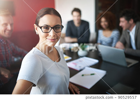 This boardroom is where success begins. Portrait of a young office worker in a meeting with colleagues in the background. This boardroom is where success begins. Portrait of a young office worker in a meeting with colleagues in the background. 90529557