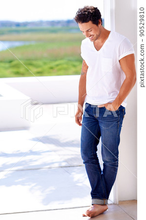 Feeling content in his new home. Shot of a handsome man standing outside of his house. Feeling content in his new home. Shot of a handsome man standing outside of his house. 90529810