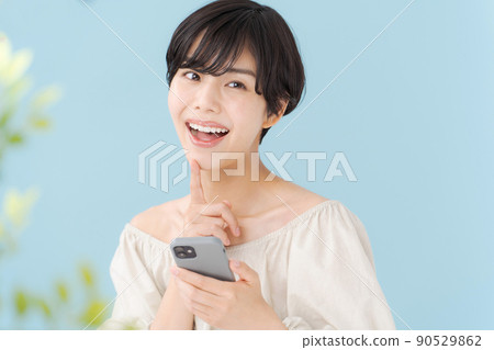 A woman with a smartphone, light blue, blue 90529862