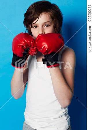 Training for the next big fight. Portrait of a young boy wearing boxing gloves in the studio. 90530021