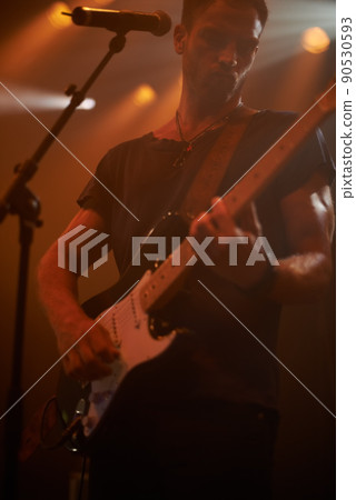 Lost in his tunes. Shot of a band playing at a music festival. 90530593
