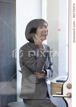 Soundproof office box Business woman speaking at a telework booth Soundproof office box Business woman speaking at a telework booth 90530954