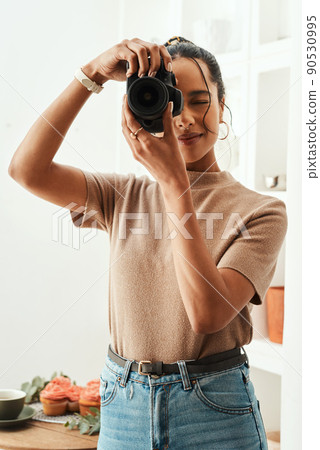Say cheese. Cropped shot of an attractive young businesswoman standing alone in her home and taking a picture with her camera. Say cheese. Cropped shot of an attractive young businesswoman standing alone in her home and taking a picture with her camera. 90530995