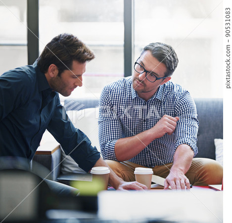 Partnering up on the project. Shot of two coworkers in a meeting in an office. 90531083
