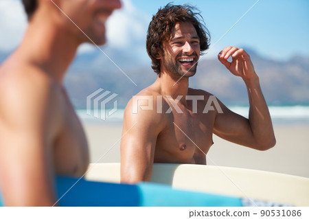 Excited for some surfing. Two friends making their way to the ocean, joking along the way. 90531086