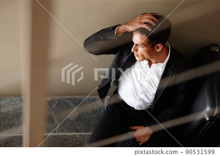 Tired of all this business travelling. Shot of an exhausted young businessman sitting on the floor beside his luggage. 90531599