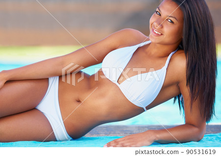 Summer beauty. Young woman reclining by the side of a swimming pool with a smile. Summer beauty. Young woman reclining by the side of a swimming pool with a smile. 90531619