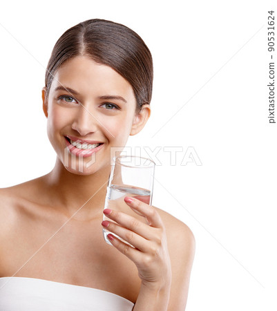 Keep your skin clear by drinking water. Studio portrait of a beautiful young woman holding a glass of water against a white background. Keep your skin clear by drinking water. Studio portrait of a beautiful young woman holding a glass of water against a white background. 90531624