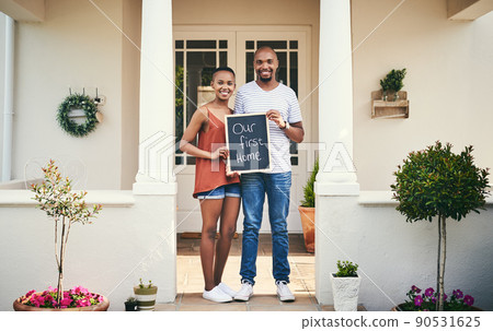 We bought our first house. Portrait of a young couple holding a chalkboard with our first home written on it. We bought our first house. Portrait of a young couple holding a chalkboard with our first home written on it. 90531625